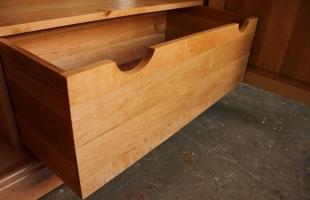 Drewniana szuflada w całości bez metalowych uchwytów wewnątrz w środku szafy zabudowy drewnianej